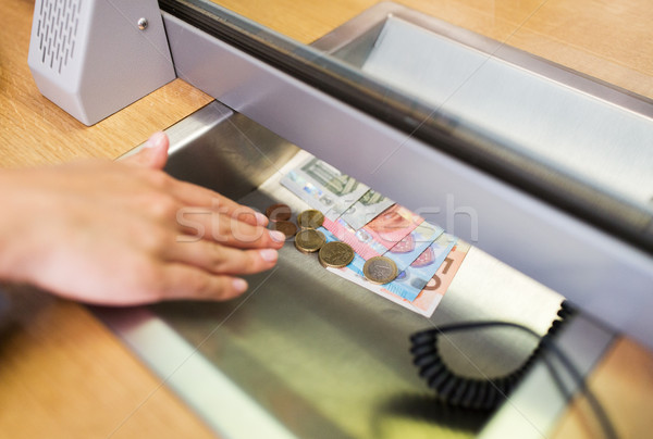 hand with cash money at bank office or exchanger Stock photo © dolgachov