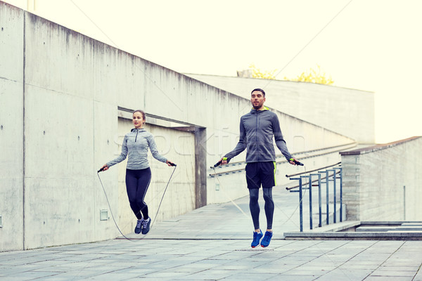 Stock photo: man and woman exercising with jump-rope outdoors