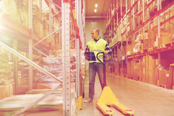 man with loader and clipboard at warehouse Stock photo © dolgachov