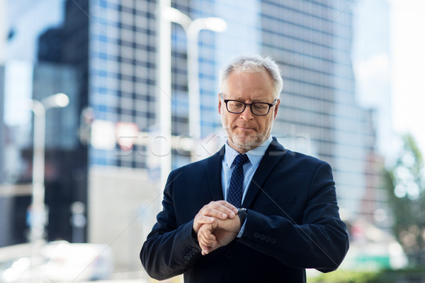 senior businessman checking time on his wristwatch Stock photo © dolgachov