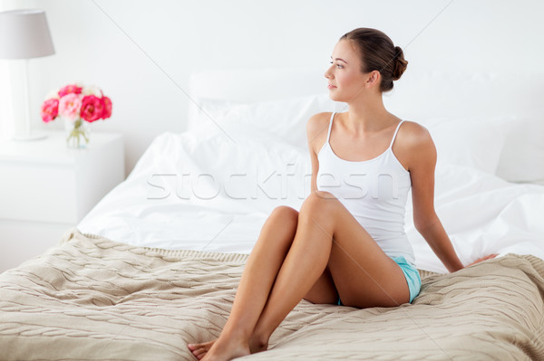 beautiful woman with bare legs on bed at home Stock photo © dolgachov