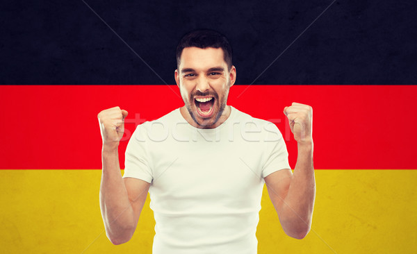 angry man showing fists over german flag Stock photo © dolgachov
