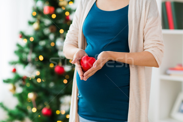 Stock photo: close up of pregnant woman with heart at christmas