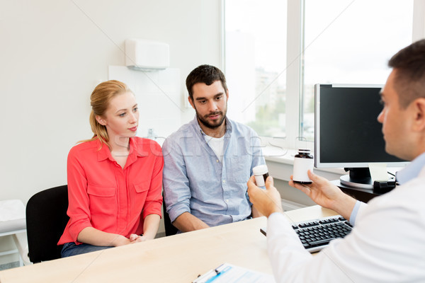 doctor showing medicine to family couple at clinic Stock photo © dolgachov