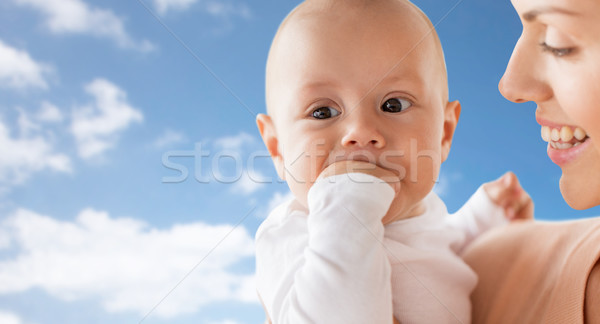 happy mother with baby sucking fingers over sky Stock photo © dolgachov
