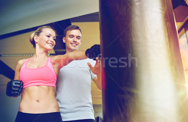 smiling woman with personal trainer boxing in gym Stock photo © dolgachov