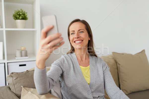 happy woman taking selfie by smartphone at home Stock photo © dolgachov