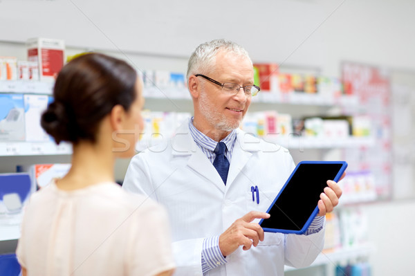 apothecary and customer with tablet pc at pharmacy Stock photo © dolgachov