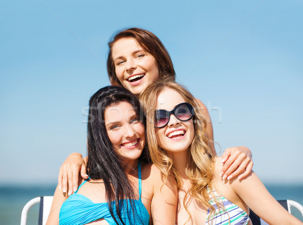 girls sunbathing on the beach chairs Stock photo © dolgachov