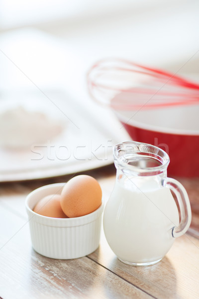 jugful of milk, eggs in a bowl and flour Stock photo © dolgachov