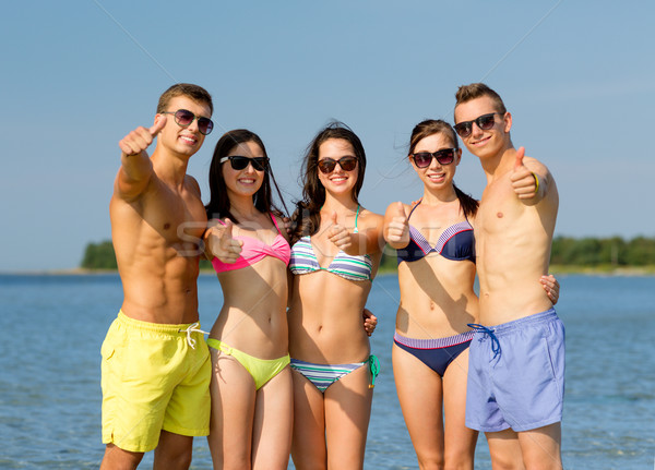 smiling friends in sunglasses on summer beach Stock photo © dolgachov