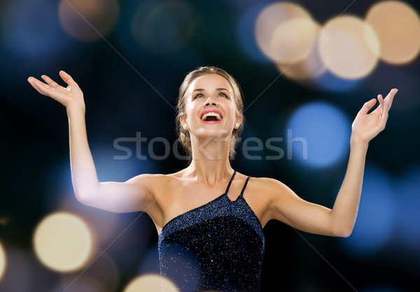 laughing woman rising hands and looking up Stock photo © dolgachov