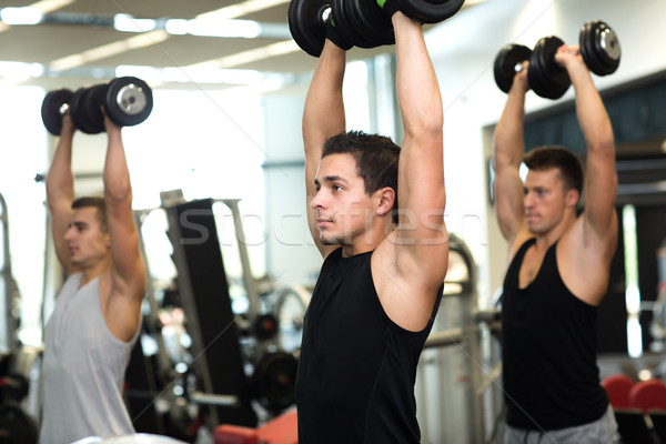 group of men with dumbbells in gym Stock photo © dolgachov
