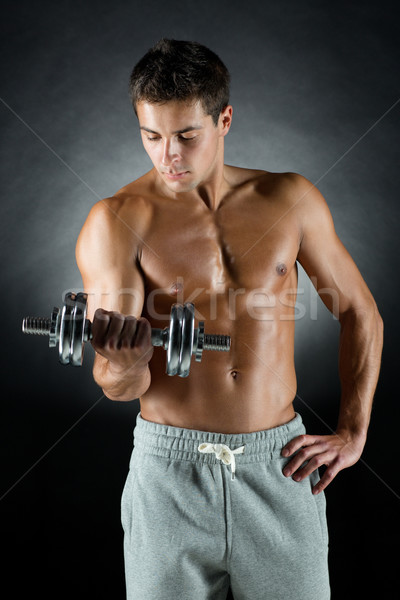 young man with dumbbell Stock photo © dolgachov
