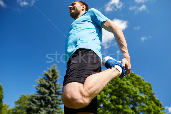 smiling man stretching outdoors Stock photo © dolgachov