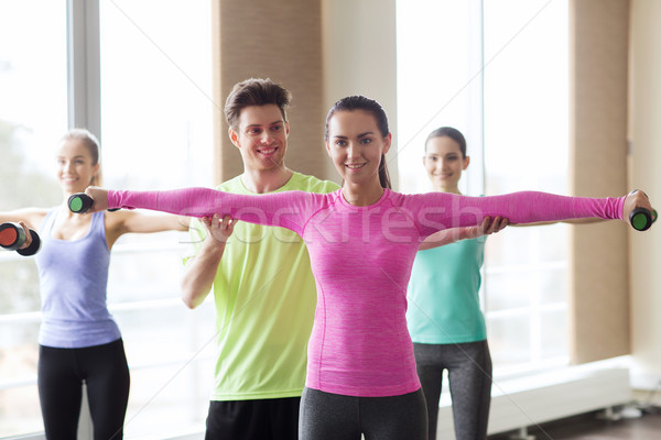 Heureux femmes entraîneur haltères gymnase fitness [[stock_photo]] © dolgachov