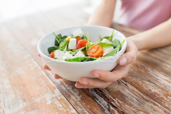 close up of young woman hands showing salad bowl Stock photo © dolgachov
