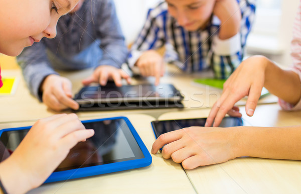 close up of school kids playing with tablet pc  Stock photo © dolgachov
