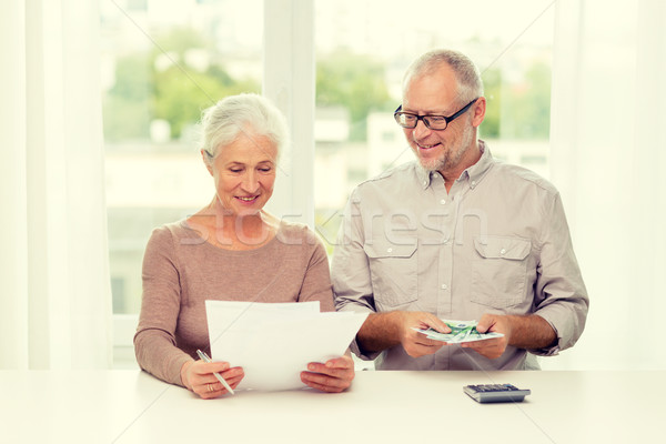 senior couple with money and calculator at home Stock photo © dolgachov