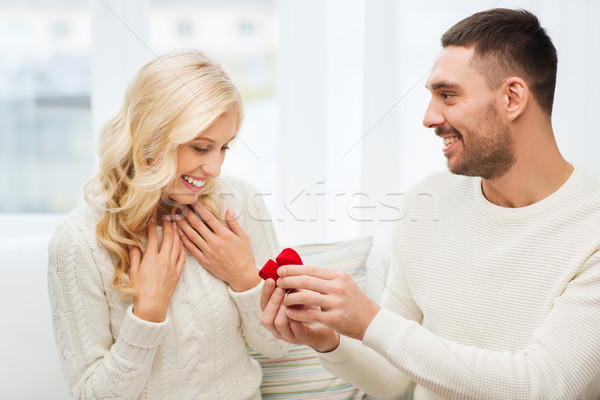 happy man giving engagement ring to woman at home Stock photo © dolgachov