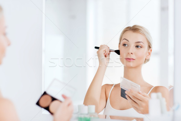 woman with makeup brush and foundation at bathroom Stock photo © dolgachov