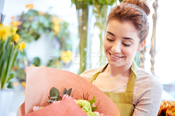 Stock photo: smiling florist woman with bunch at flower shop