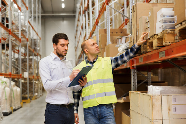 worker and businessmen with clipboard at warehouse Stock photo © dolgachov