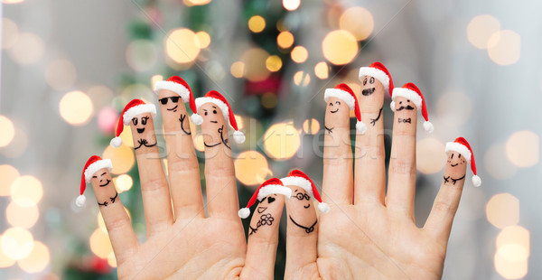 close up of fingers with smiley in santa hats Stock photo © dolgachov