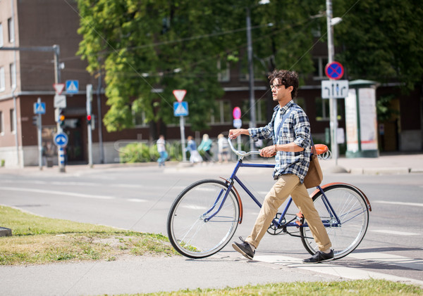 young man with fixed gear bicycle on crosswalk Stock photo © dolgachov