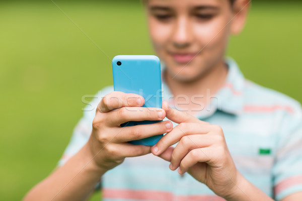 boy with smartphone outdoors at summer Stock photo © dolgachov