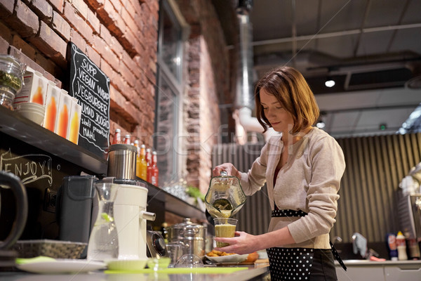 woman or barmaid cooking smoothie at vegan cafe Stock photo © dolgachov