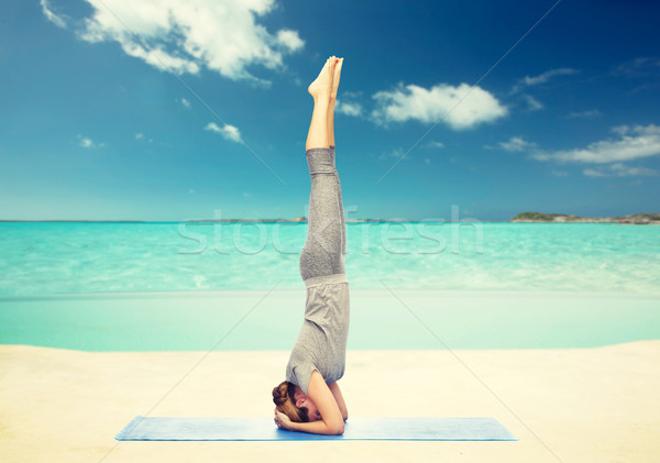 woman making yoga in headstand pose on beach  Stock photo © dolgachov