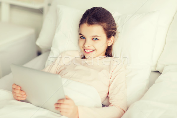 Boldog lány ágy táblagép otthon emberek gyerekek Stock fotó © dolgachov