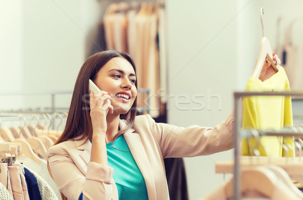 Stock photo: woman calling on smartphone at clothing store