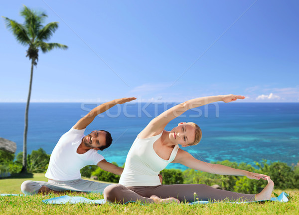 happy couple making yoga exercises outdoors Stock photo © dolgachov