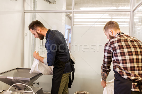 men with malt bags and mill at craft beer brewery Stock photo © dolgachov