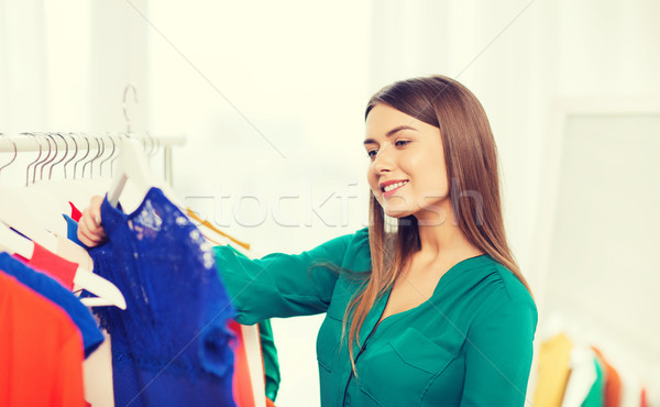 Stock photo: happy woman choosing clothes at home wardrobe