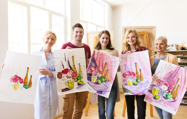 group of artists with pictures at art school Stock photo © dolgachov