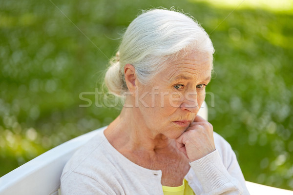 sad senior woman sitting on bench at summer park Stock photo © dolgachov