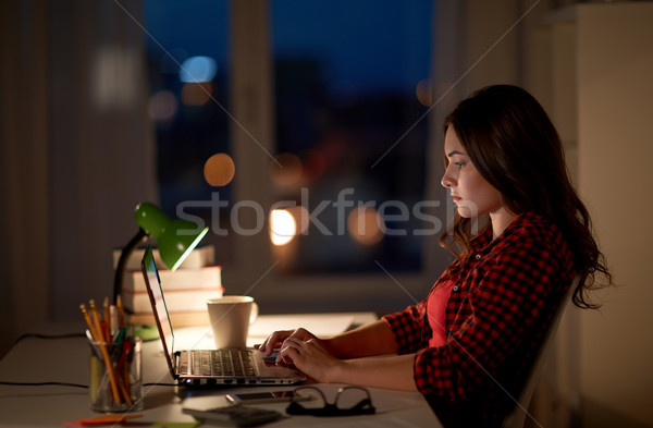 student or woman typing on laptop at night home Stock photo © dolgachov