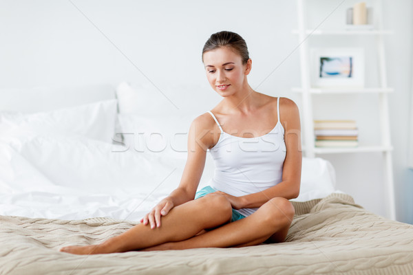 beautiful woman with bare legs on bed at home Stock photo © dolgachov