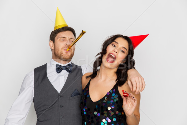 happy couple with party blowers having fun Stock photo © dolgachov