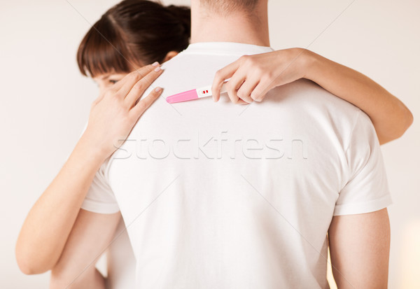 woman with pregnancy test hugging man Stock photo © dolgachov