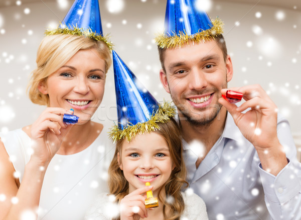 Stock photo: smiling family in blue hats blowing favor horns