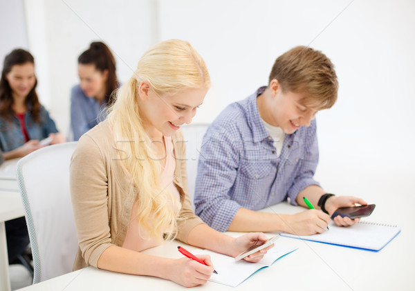 Stock photo: smiling students with notebooks at school