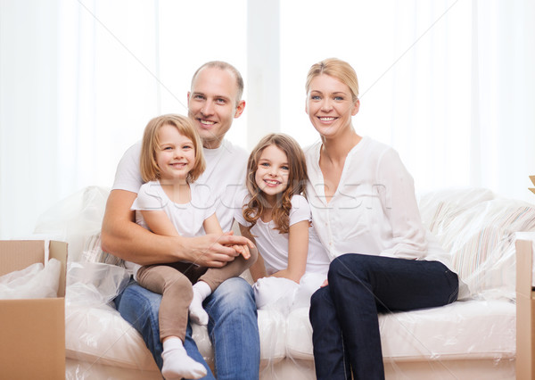 Sonriendo padres dos niñas nuevo hogar familia Foto stock © dolgachov