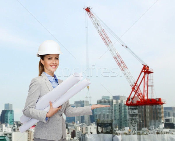 Stock photo: smiling architect in helmet with blueprint
