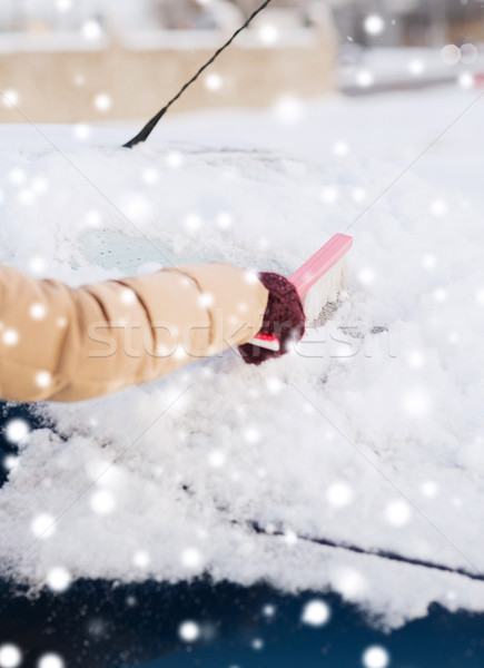 Stock photo: closeup of woman cleaning snow from car