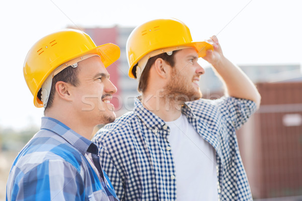 Stock photo: group of smiling builders in hardhats outdoors