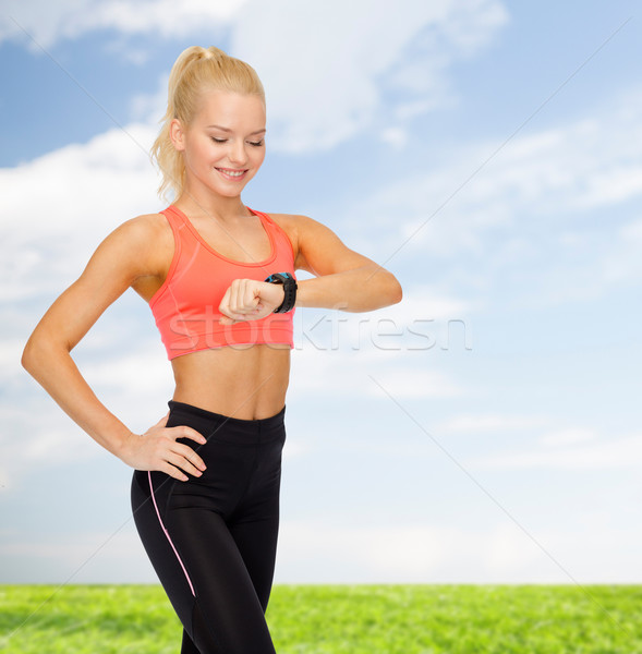 Donna sorridente frequenza cardiaca monitor mano fitness tecnologia Foto d'archivio © dolgachov